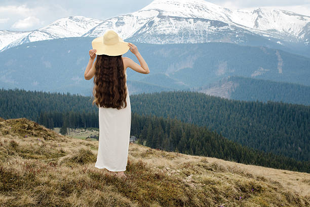Young woman standing on a hillside in the mountains