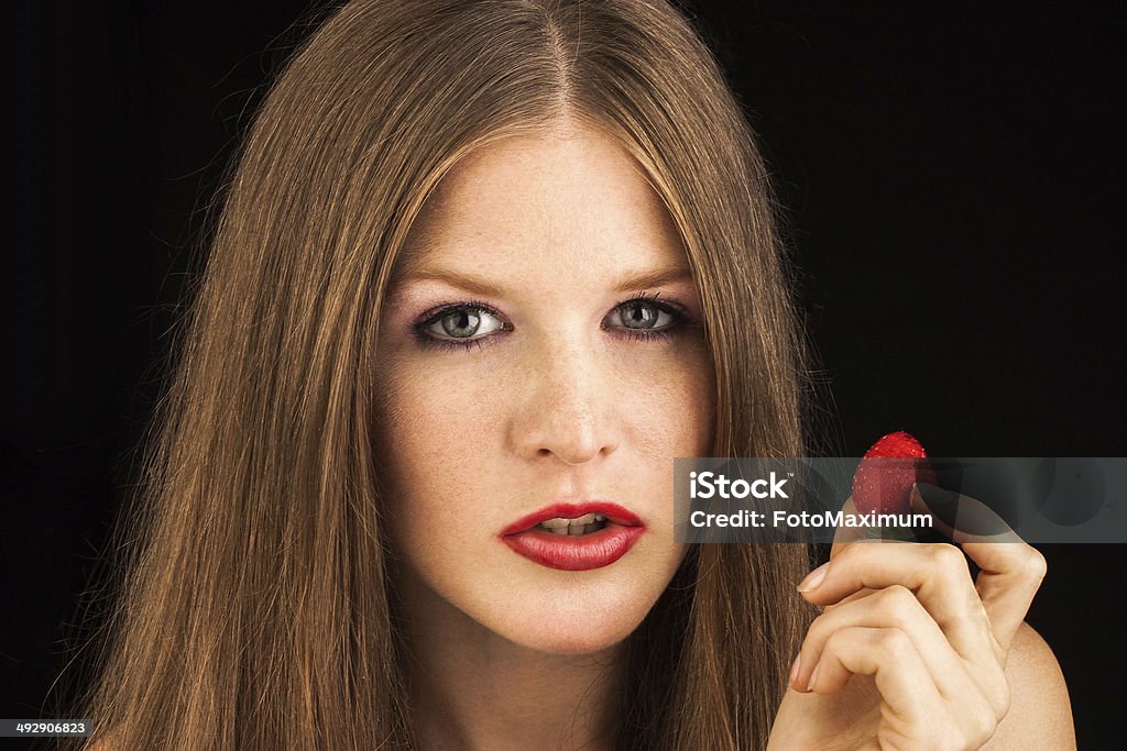 Jeune femme manger une fraise - Photo de Adulte libre de droits