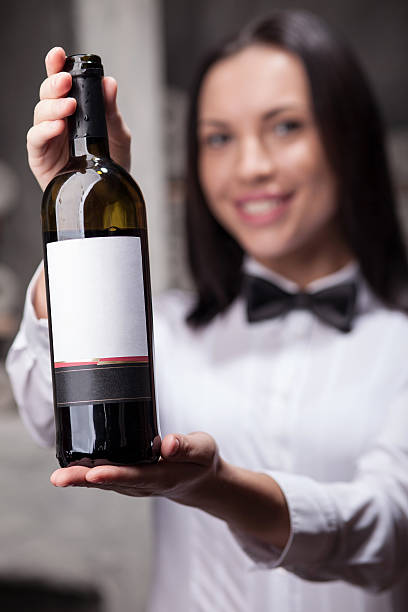 istock Cute female liquor store assistant is presenting drink 492907408