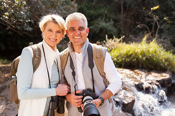 istock mid age couple standing in mountain valley 492910058