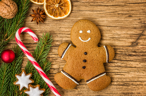 A gingerbread man on a wooden background with christmas decorations