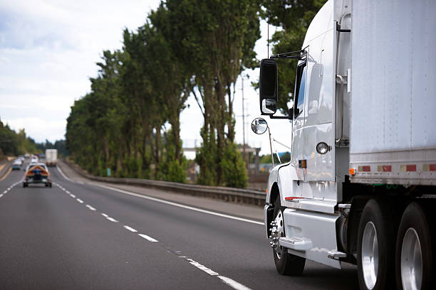 istock Modern semi truck on wide highway stretching into distance 492911304