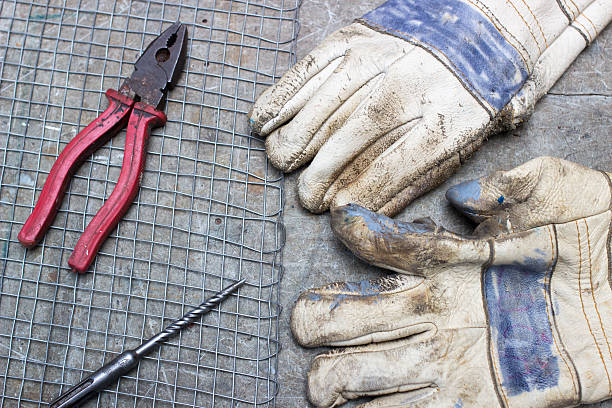 istock Scissors, gloves and a drill on the old wooden desk 492912094