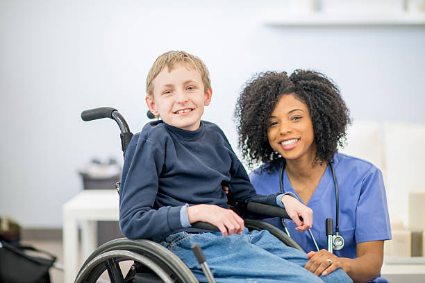 istock Little Boy in a Wheelchair with A Nurse 492914400