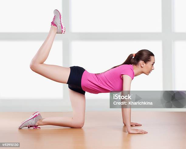 Beautiful Young Brunette Woman Stretching The Muscles Of Her Arm Stock Photo - Download Image Now