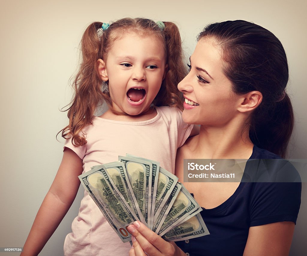 Happy smiling family holding dollars and thinking how to spend Happy smiling family holding dollars and thinking how to spend the money. Vintage closeup portrait Child Stock Photo