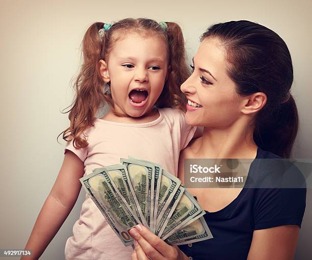 Happy Smiling Family Holding Dollars And Thinking How To Spend Stock Photo - Download Image Now