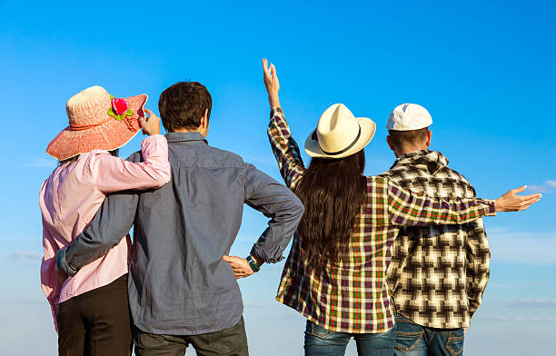 Group of Young People Casual Clothing Having Fun Together on Blue Sky Background from Back