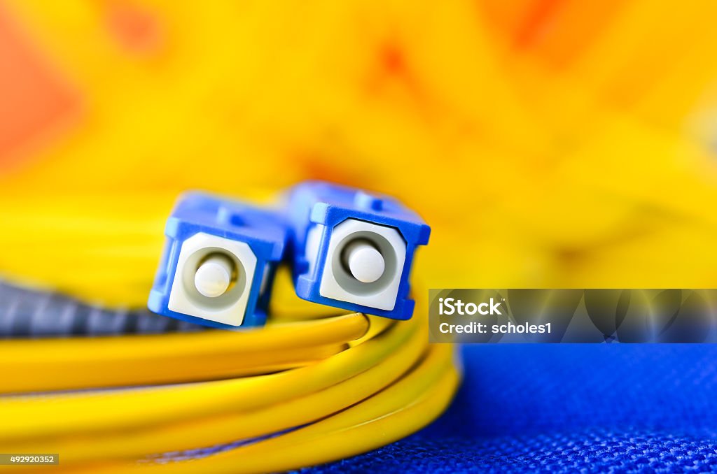 Fiber optic connectors close up on a colourful background. Fiber Optic Stock Photo