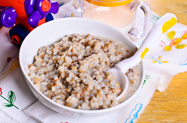 Porridge buckwheat with milk for baby food in a ceramic plate