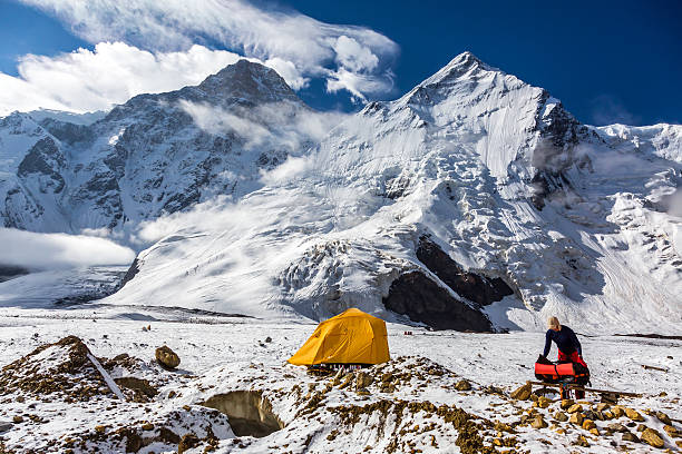istock Mountain View Orange Tent Alpinist Holding Backpack 492933384