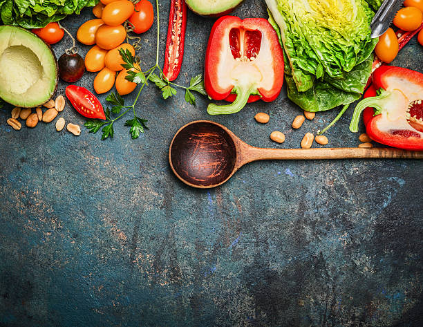 鮮やかなオーガニック野菜と食材を用い、木製スプーン - vegetable fruit cutting board plank ストックフォトと画像