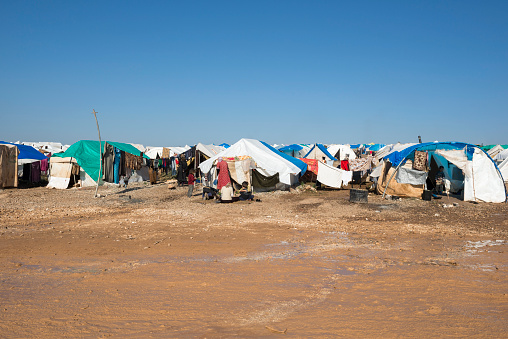 Atmeh, Syria - January 14, 2013: Internally displaced Syrians sit outside their tents at a camp in Atmeh, Syria