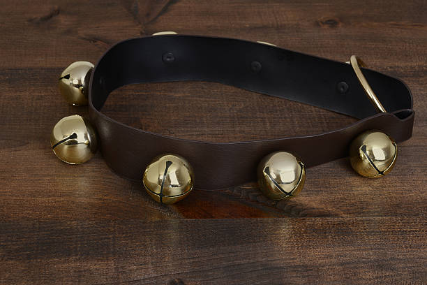 closeup of gold sleigh bells on wood