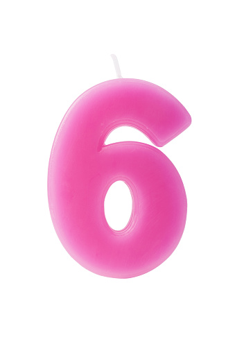 Pink birthday candle in the form of the number six on white background