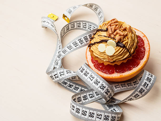 istock Grapefruit and cake with measuring tape. Diet 492959960