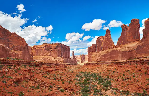 View of Courthouse Towers and Klondike Bluffs from the Park Avenue Trailhead in Arches National Park. Spectacular perspective of the receding layers of landscape in the red rocks.