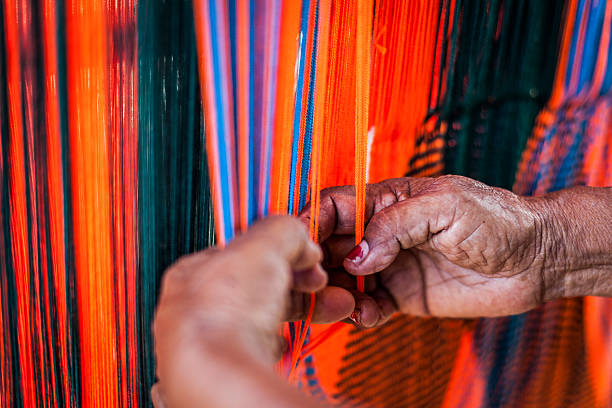 Woman weaving a Wayuu hammock (chinchorro). Woman weaving a "chinchorro", or Colombian hammock, in the town of Uribia.  Knitting, crocheting and weaving are fundamental to the social and economic lives of Wayuu women in La Guajira, Colombia. tapestry photos stock pictures, royalty-free photos & images