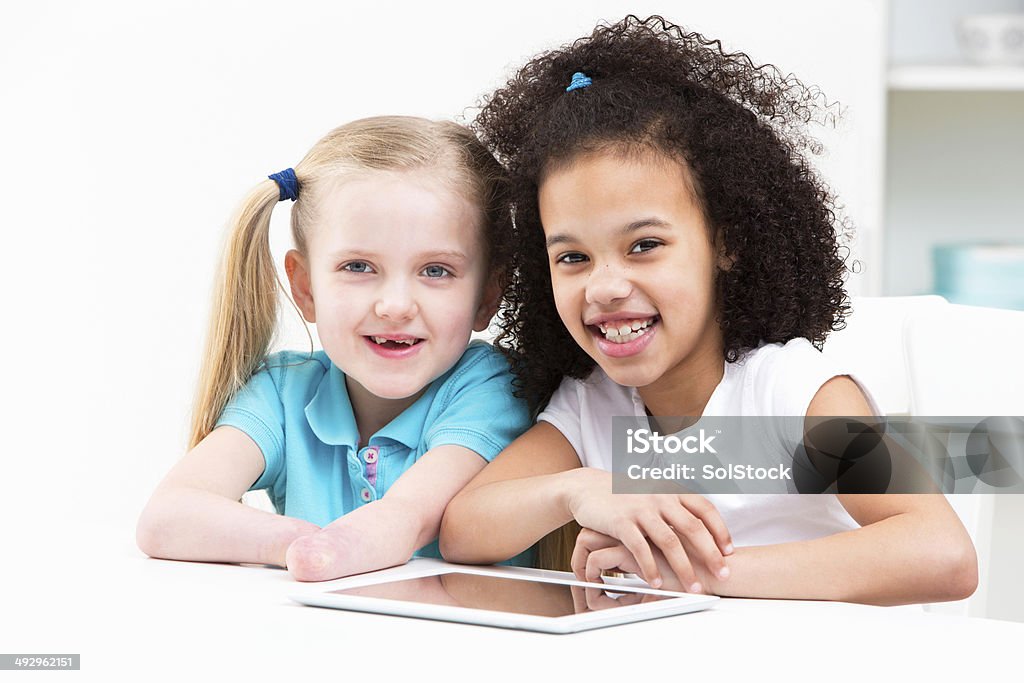 Discapacitados niño con sus amigos usando tableta Digital en su casa - Foto de stock de 6-7 años libre de derechos