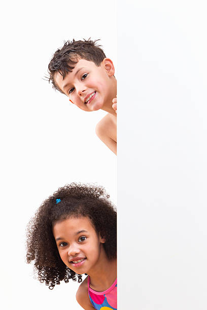 istock Children In Swimsuits Looking Around White Wall At Studio 492962235