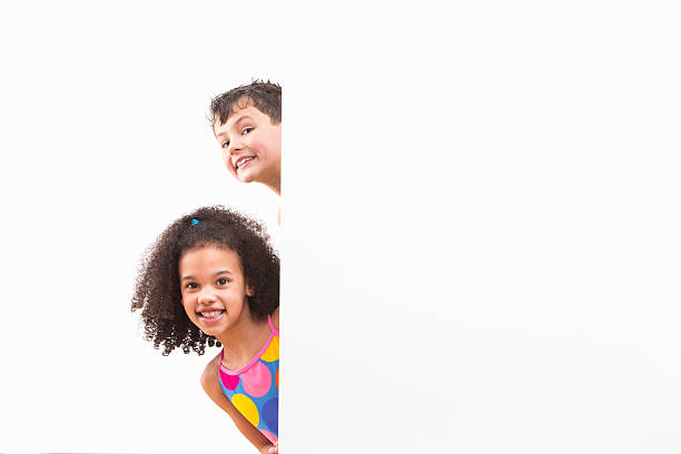 istock Children In Swimsuits Looking Around White Wall At Studio 492962239