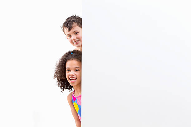 Children In Swimsuits Looking Around White Wall At Studio