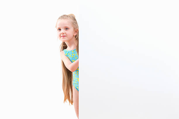 istock Girl In Swimsuit Looking Around White Wall At Studio 492962269