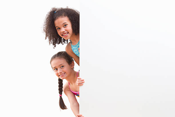 istock Children In Swimsuits Looking Around White Wall At Studio 492962291
