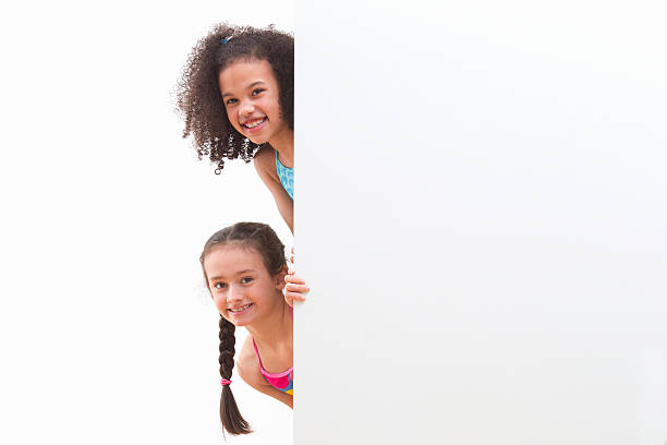istock Children In Swimsuits Looking Around White Wall At Studio 492962293