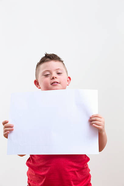 istock Boy With Downs Syndrome Holds Blank Sign On White Background 492962327
