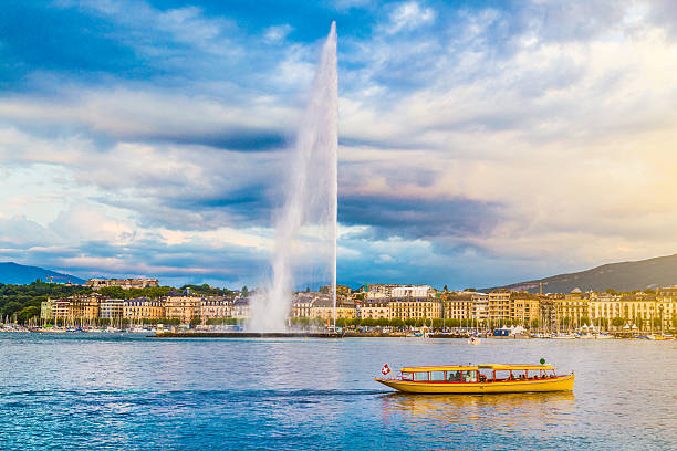 City of Geneva with Jet d'Eau fountain at sunset, Switzerland Beautiful view of Geneva skyline with famous Jet d'Eau fountain at harbor district in beautiful evening light, Switzerland. geneva switzerland photos stock pictures, royalty-free photos & images