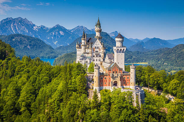 Famous Neuschwanstein Castle with scenic mountain landscape near Fussen, Germany - August 7, 2015: Beautiful view of world-famous Neuschwanstein Castle, the nineteenth-century Romanesque Revival palace built for King Ludwig II on a rugged cliff, with scenic mountain landscape near Fussen, southwest Bavaria, Germany. munich photos stock pictures, royalty-free photos & images
