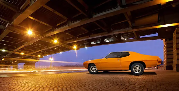 Classic muscle car Pontiac GTO 1970 standing under the bridge.