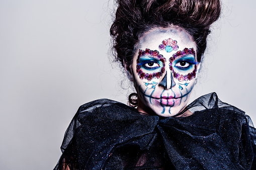 Portrait of young woman with Sugar skull creative make up for halloween.