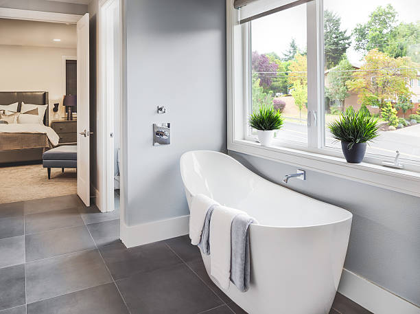 Bathroom Interior in Luxury Home Bathtub in master bathroom in new luxury home with view of master bedroom and neighborhood with trees  through window owners bedroom photos stock pictures, royalty-free photos & images