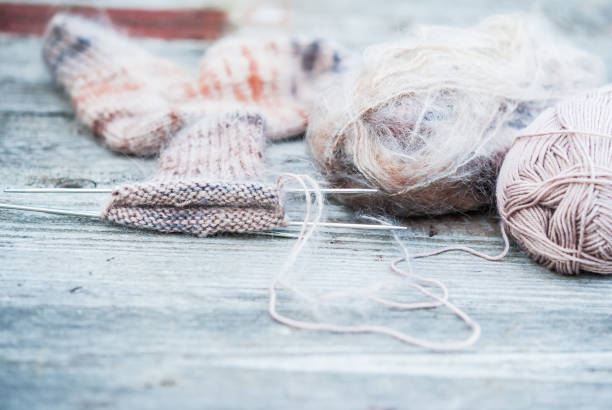 istock Woolen thread with incomplete knitting socks on vintage wooden background 492965362