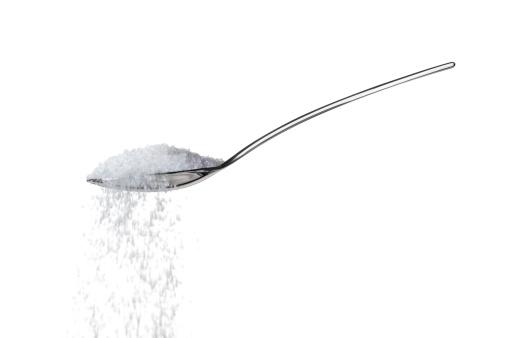 sugar/salt on teaspoon over white