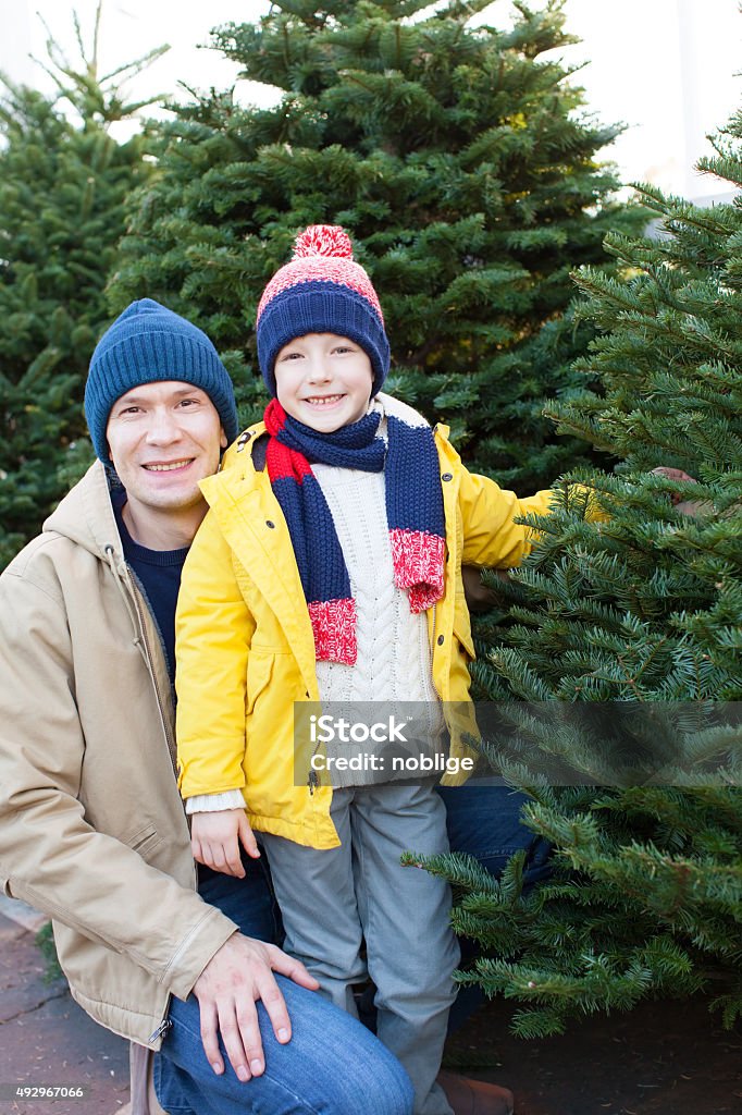 family shopping for christmas tree little smiling boy and his father shopping for christmas tree 2015 Stock Photo