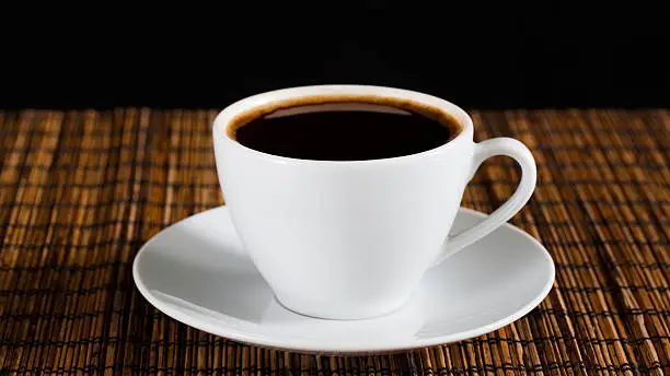 Photo of natural black coffee in a white cup