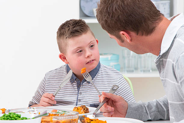 istock Father With Disabled Son Eating Meal At Home 492967341
