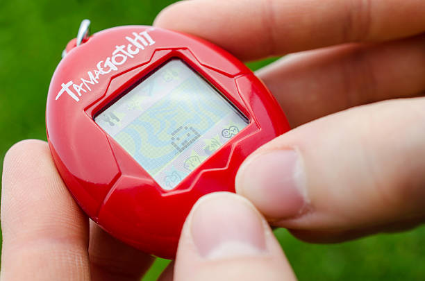 spielt mit tamagotchi - hotizontal stock-fotos und bilder