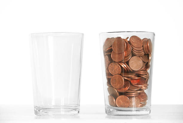 One empty glass and one glass full of change