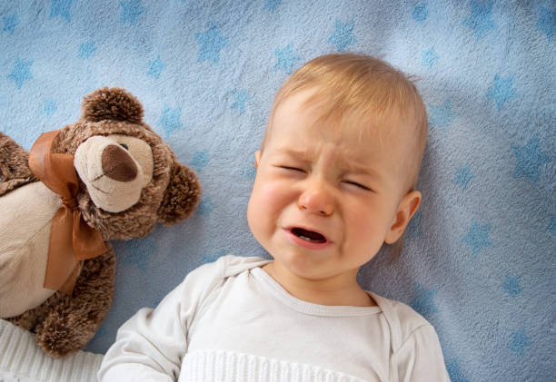 un anno di età bambino piange - baby sleeping bedding teddy bear foto e immagini stock
