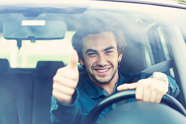 istock Young man thumbs up gesture in car 492985498
