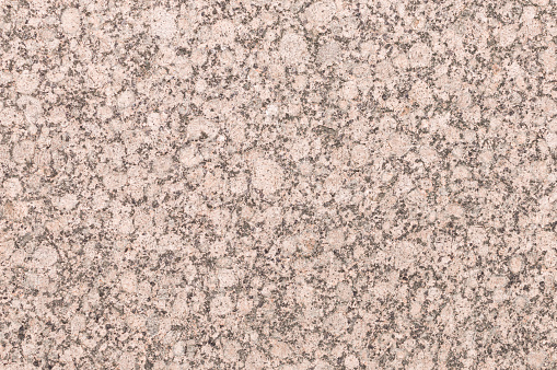 Mineral background with red or pink granite texture cut and unpolished surface of decorative trim stone