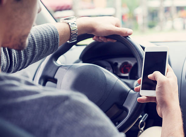 istock Young man driving car and using mobile phone 492988312