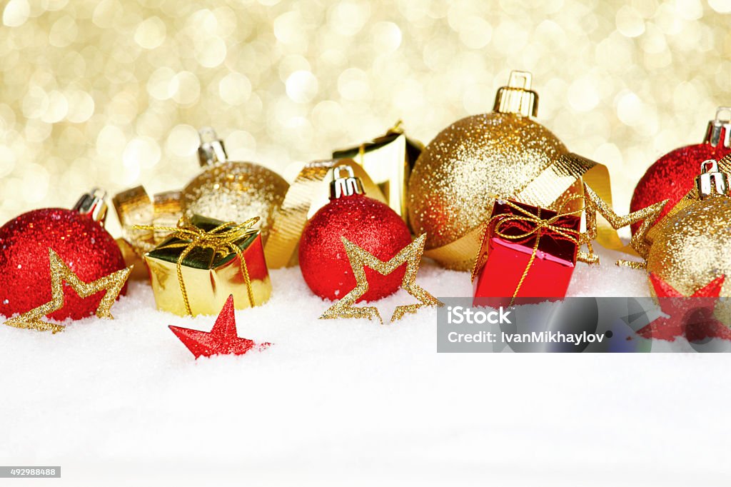 Christmas decorations in snow Christmas card with colorful decorations in snow on gold background 2015 Stock Photo
