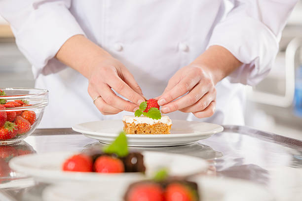 istock Chef decorates dessert cake with strawberry 492989912