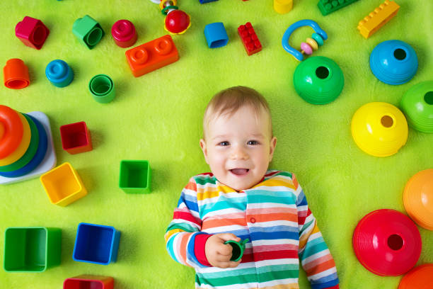 istock Baby boy lying on the blanket with many toys around 492995398