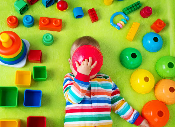 istock Baby boy lying on the blanket with many toys around 492995408